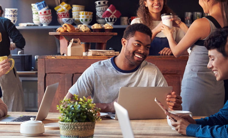 young people in coworking setting with coffee and laptops