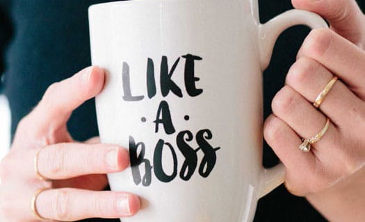 Woman holding mug inscribed with 'like a boss'