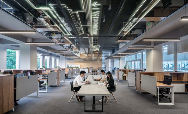 open plan office with workers seated at a central table