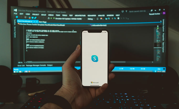 desktop screen at home with iphone with Skype logo