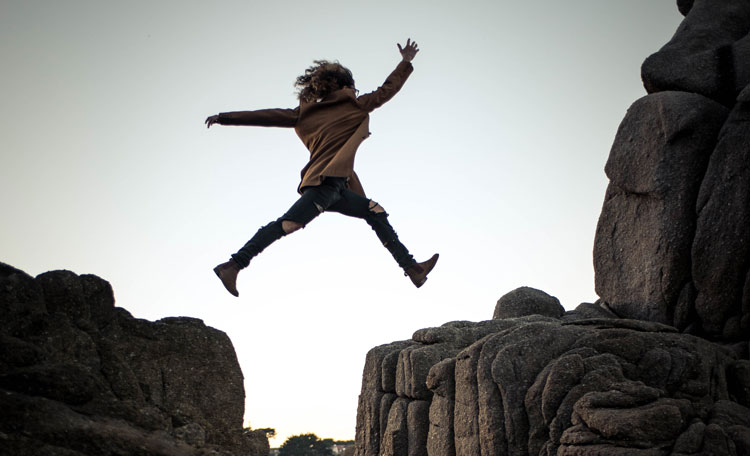 woman leaping at Big Sur, California